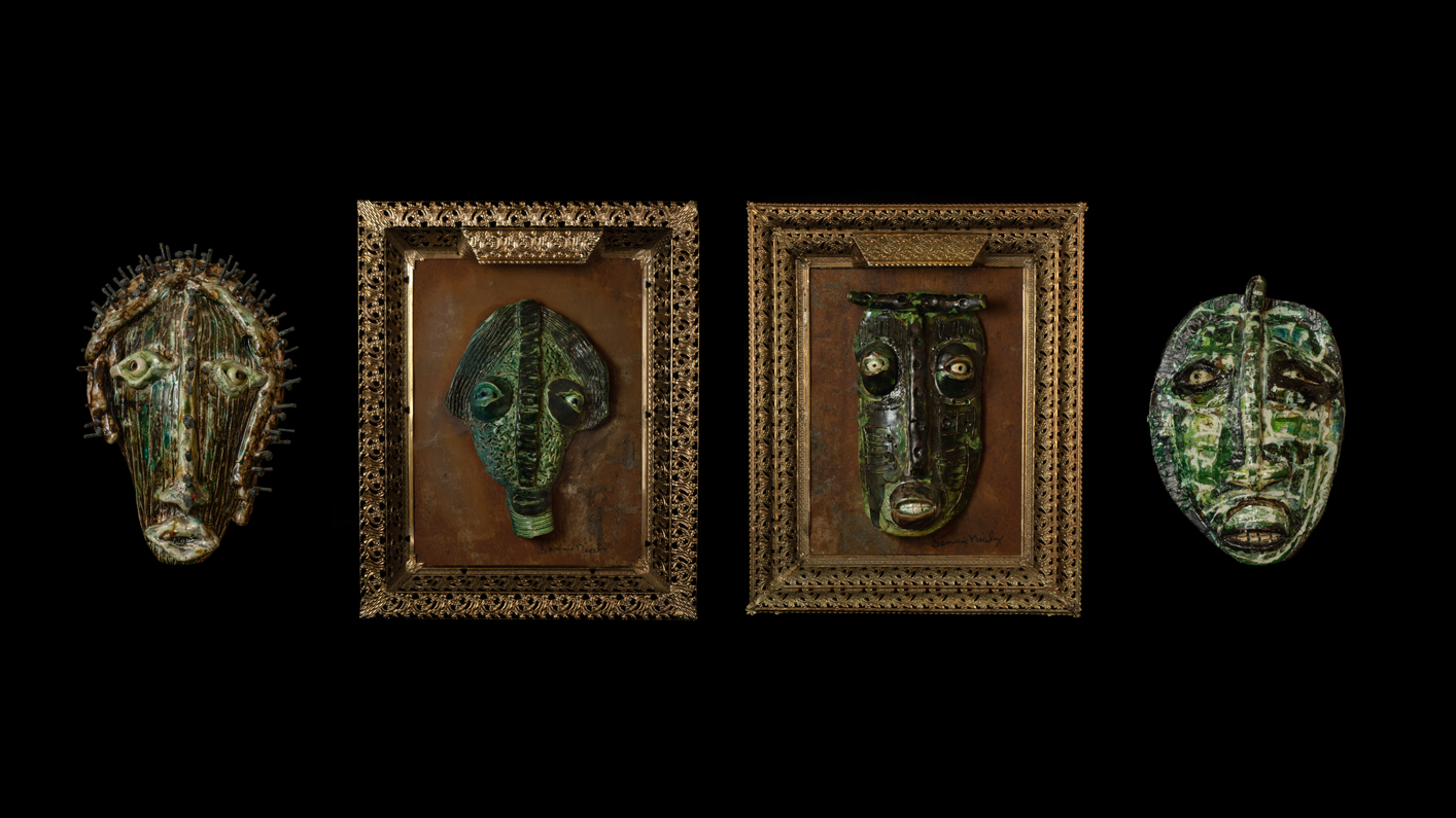 This image shows four green ceramic masks by artist Sammie L. Nicely on a black background. This photograph is by Billie Wheeler.